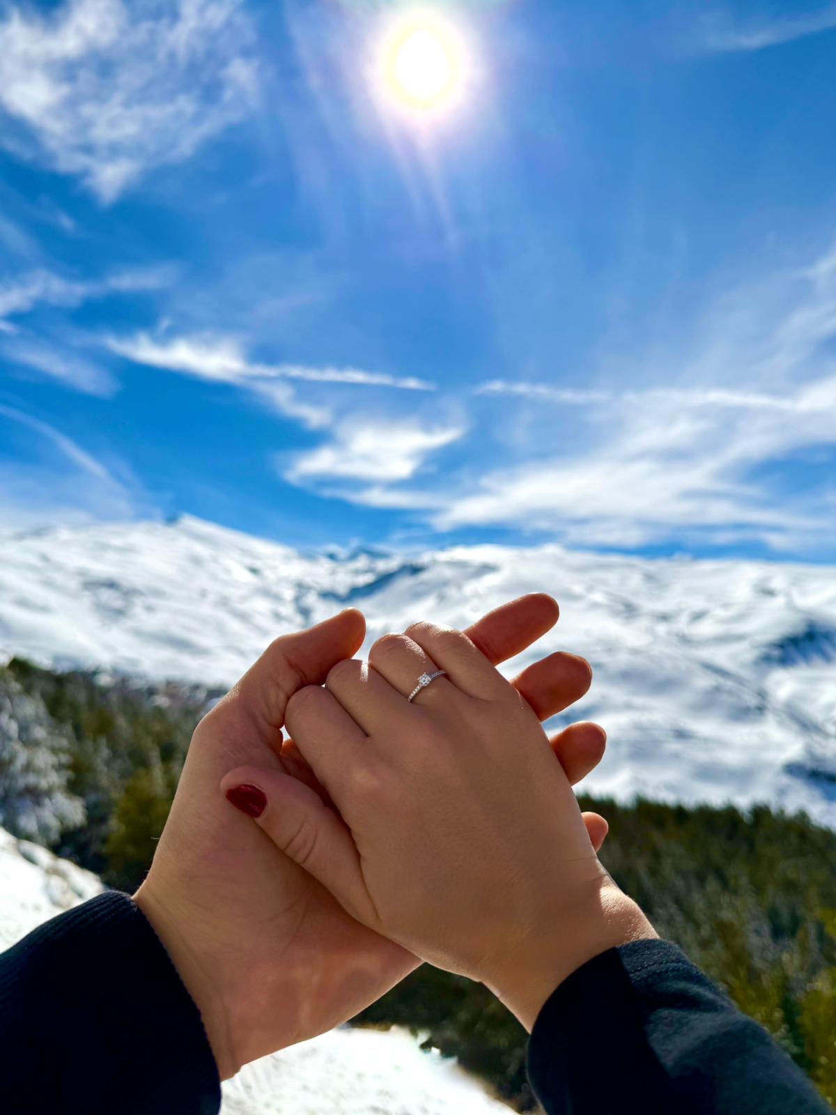 Nuestras manos con el anillo de compromiso, con la sierra nevada detrás